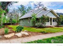 Charming home featuring a well-manicured lawn, quaint front porch, and beautiful landscaping at 322 Vivian St, Longmont, CO 80501