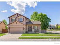 Charming two-story home with a well-maintained lawn, inviting front porch and an attached two car garage at 548 Mathews Cir, Erie, CO 80516