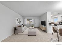 Bright living room features neutral decor, a comfortable sofa, and seamless flow into the adjacent kitchen at 9868 Appletree Pl, Thornton, CO 80260
