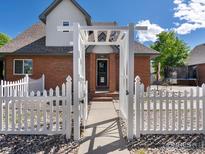 View of fenced backyard with pergola, brick home and landscaping at 101 Se 2Nd St, Berthoud, CO 80513