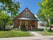 Charming brick home featuring a classic design, landscaped yard, and inviting front porch at 101 Se 2Nd St, Berthoud, CO 80513