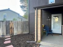 Inviting front porch with brick pillar, cute chair, and fresh mulch creating a welcoming entrance to the home at 1215 Centaur Cir # A, Lafayette, CO 80026