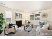 Bright living room featuring a fireplace, large windows, and modern decor at 1215 Centaur Cir # A, Lafayette, CO 80026