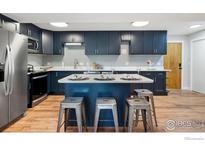 Charming kitchen with an island, modern appliances, blue cabinets, and ample counter space at 1606 Cottonwood Dr # 16S, Louisville, CO 80027