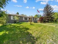 Charming single-story home with a spacious front lawn and mature trees at 1815 9Th Ave, Longmont, CO 80501