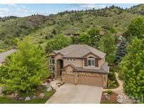 Beautiful two-story home with stone accents and a well-manicured front yard with mountain views at 19061 Eagle Ridge Dr, Golden, CO 80401