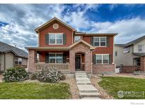 Charming two-story home with brick accents, covered porch, and well-maintained lawn at 2190 Winding Dr, Longmont, CO 80504