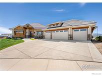 Expansive home featuring a three-car garage, beautiful stonework, manicured lawn, and plentiful natural light at 2387 Harding Park Ct, Berthoud, CO 80513
