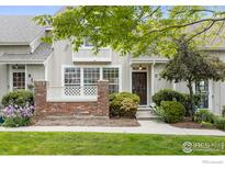 Charming townhouse exterior with a well-maintained lawn and a decorative brick fence, perfect for low-maintenance living at 2982 W Long Dr # C, Littleton, CO 80120