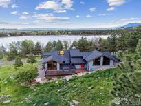 Beautiful waterfront home featuring a deck overlooking the lake and a lovely, landscaped yard at 3021 N Lakeridge Trl, Boulder, CO 80302