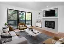 Sun-filled living room featuring stylish furniture, a cozy fireplace, and access to a private balcony at 3275 34Th St # 76, Boulder, CO 80301
