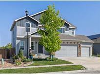 Charming two-story home with a well-manicured lawn and a two car garage with stone details at 6681 6Th St, Frederick, CO 80530
