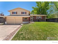 Charming two-story home features a well-maintained lawn, brick accents, and a two-car garage at 9084 W Rice Ave, Littleton, CO 80123