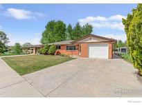 Charming brick home featuring an attached garage and well-maintained front lawn at 1229 Juniper St, Longmont, CO 80501