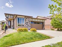 Charming single-Gathering home boasts a well-manicured lawn and stone accents at 12556 W Montane Dr, Broomfield, CO 80021