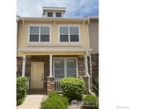 Charming two-story home with yellow siding, stone accents, and a welcoming front porch at 13624 Garfield St # B, Thornton, CO 80602