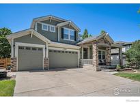 Inviting two-story home with a three-car garage, stone accents, and a covered front porch at 15562 E 109Th Ave, Commerce City, CO 80022