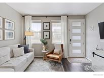 Bright living room featuring a comfortable sofa, stylish chair, and ample natural light through large windows at 21823 E 8Th Ave, Aurora, CO 80018