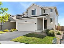 Charming two-story home with a two-car garage, landscaped yard, and welcoming front porch at 2672 Prairiestar Dr, Berthoud, CO 80513