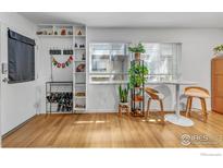 Bright living area featuring hardwood floors, built-in shelves, and two windows at 3313 Madison Ave # 212, Boulder, CO 80303