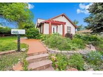 Charming home with a colorful front yard, red pergola, and inviting walkway at 529 Main St, Louisville, CO 80027
