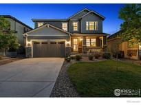 Beautiful two-story home with a well-manicured lawn, stone accents and a two car garage with concrete driveway at 610 Sun Up Pl, Erie, CO 80516