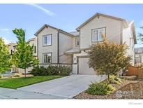 Charming two-story home with a well-manicured lawn, gray siding, and a concrete driveway leading to the garage at 6229 Black Mesa Rd, Frederick, CO 80516