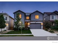 Charming two-story home featuring a two-car garage, well-kept lawn, and tasteful exterior lighting at 6229 Black Mesa Rd, Frederick, CO 80516