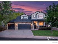 Charming two-story home featuring a stone facade, three-car garage, and well-manicured lawn at 6488 Tilbury Ave, Firestone, CO 80504