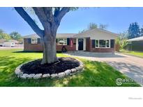 Charming brick home featuring well-manicured lawn and mature shade tree at 8290 Chase Way, Arvada, CO 80003