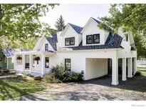 Charming white home featuring black-trimmed windows and a lovely front porch with hanging flower baskets at 920 Hawthorn Ave, Boulder, CO 80304