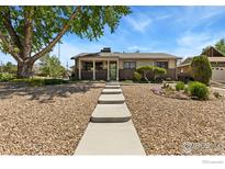 Charming ranch-style home with a landscaped front yard and inviting walkway to the front door at 9598 Lowell Blvd, Westminster, CO 80031