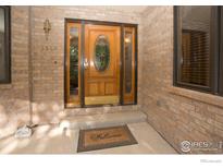 Inviting front entrance with a charming wood door and brick facade at 1314 State Highway 66 Hwy, Longmont, CO 80504