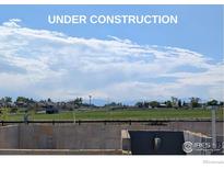 Under construction basement of home with mountain views and blue sky at 16873 Ballinger Cir, Mead, CO 80542