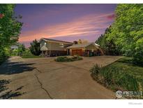 Charming two-story home with brick accents, a large driveway, and a well-manicured lawn at 1921 Glenview Ct, Berthoud, CO 80513