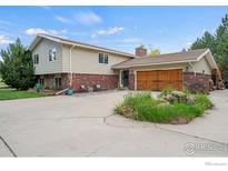 Charming two-story home with brick accents, a large driveway, and a well-maintained front yard at 1921 Glenview Ct, Berthoud, CO 80513