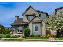 Charming two-story home featuring a well-manicured lawn and inviting front porch with seating at 2369 Hecla Dr, Louisville, CO 80027