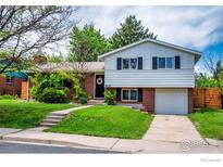 Charming split-level home featuring a brick facade, well-manicured lawn, and attached garage at 4658 Ingram Ct, Boulder, CO 80305