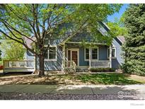 Charming two-story home with a covered porch and a well-maintained lawn at 612 Wild Ridge Ln, Lafayette, CO 80026