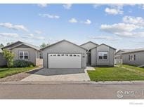 Charming single-story home with a well-maintained lawn and attached two car garage at 6150 Bluestem Grn, Frederick, CO 80530