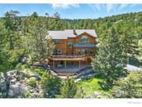 Beautiful mountain home featuring a spacious deck, natural wood siding, and mature trees at 84 Canon View Rd, Boulder, CO 80302