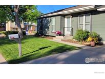 Charming home featuring a well-manicured lawn and inviting walkway at 1087 Lilac St, Broomfield, CO 80020