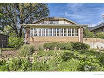 Charming brick home with a manicured front yard and beautiful landscaping at 1230 S Emerson St, Denver, CO 80210