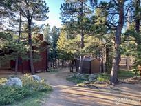 Charming cabin exterior with beautiful surrounding trees and a private, peaceful setting at 133 Mine Ln, Boulder, CO 80302