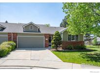Charming home with a two-car garage, brick accents, and a well-maintained front yard and blue sky at 1528 16Th Pl, Longmont, CO 80501