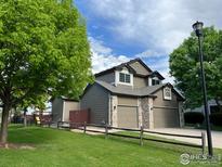 Charming two-story home featuring a well-maintained lawn, two-car garage, and beautiful landscaping at 1574 Goshawk Dr, Longmont, CO 80504