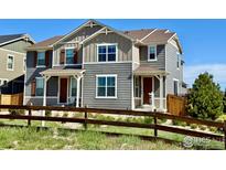 Charming two-story townhome with gray siding, brown trim, and a well-maintained front yard at 17616 Bluetrail Ave, Parker, CO 80134