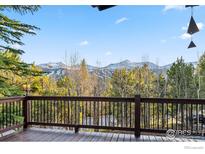 Enjoy mountain views from this wooden deck with metal railings surrounded by lush trees at 216 N Gold Flake, Breckenridge, CO 80424