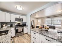 Modern kitchen features white cabinets, stainless steel appliances, and granite countertops at 3245 W Walsh Pl, Denver, CO 80219
