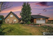Inviting single-Gathering home with a well-manicured lawn and mature trees under a beautiful sunset sky at 3412 Erving Ct, Berthoud, CO 80513